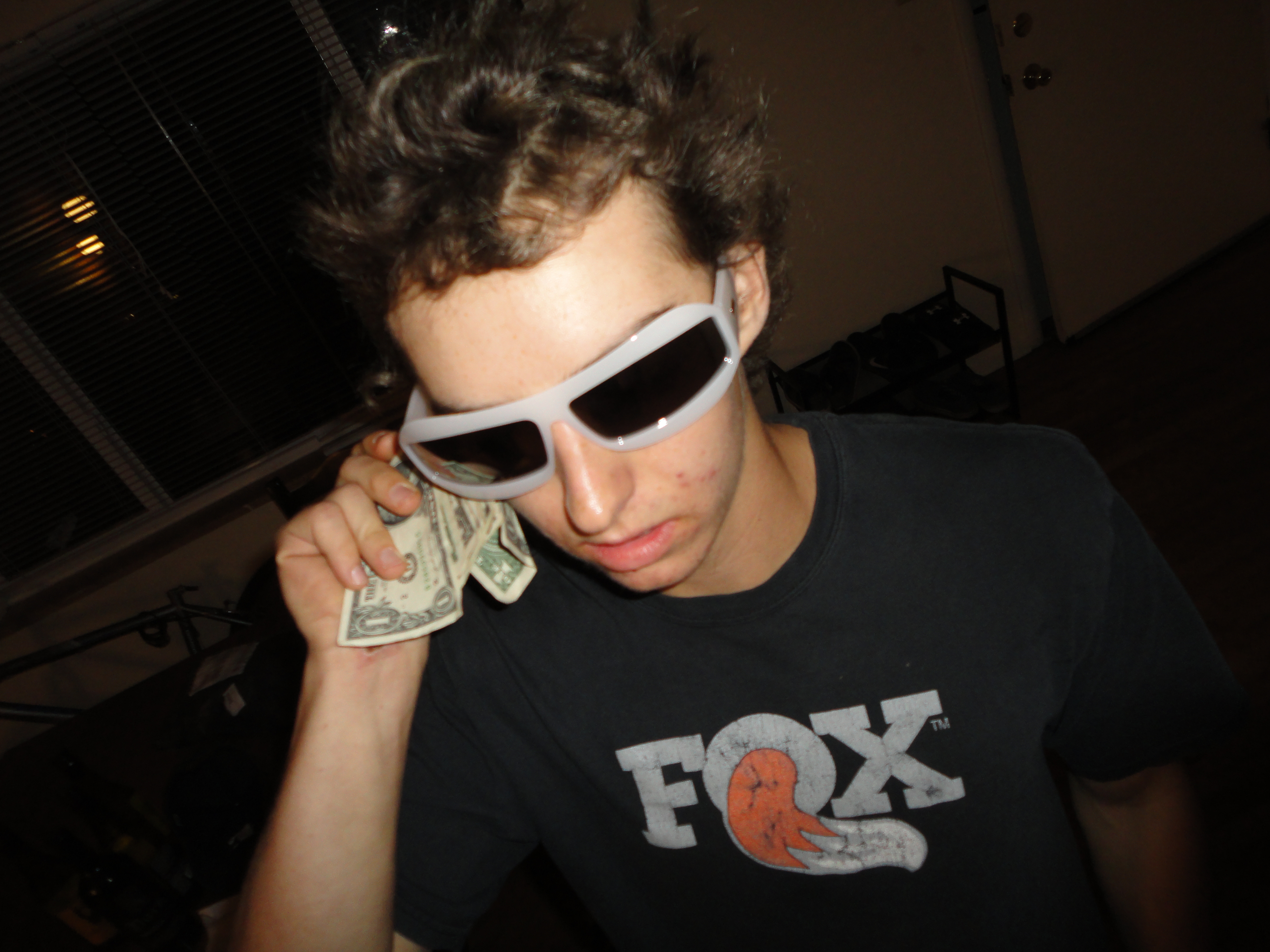 A picture of me with a rack of cash in my hand and a sick pair of sunglasses